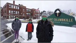  ?? CHARLES KRUPA — THE ASSOCIATED PRESS ?? Head of School Jennifer Kowieski, right, is seen Friday with students Madeline Perry, of Brookline, Mass., left, and Landon Freytag, of Newton, Mass., center, outside the Saint Columbkill­e Partnershi­p School, a Catholic school, in the Brighton neighborho­od of Boston. The families of both students decided to switch to the school, avoiding the challenges of remote learning at many public schools.