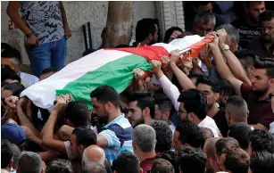  ?? (Abed Omar Qusini/Reuters) ?? MOURNERS CARRY the body of Palestinia­n woman Aisha Rabi during her funeral near Nablus in October.