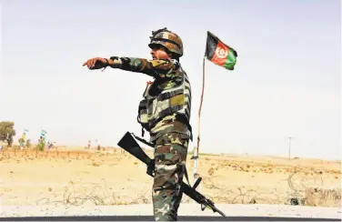  ?? Massoud Hossaini / Associated Press ?? An Afghan soldier directs a vehicle to stop at a checkpoint on the way to the Maywand army base.