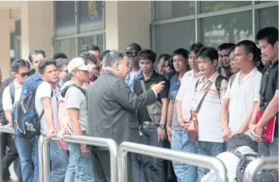  ?? APICHART JINAKUL ?? Workers gather at the Immigratio­n Bureau yesterday to lodge a complaint accusing a job brokerage firm of providing false informatio­n about working in the United Arab Emirates. Many of them also complained they had not been paid.