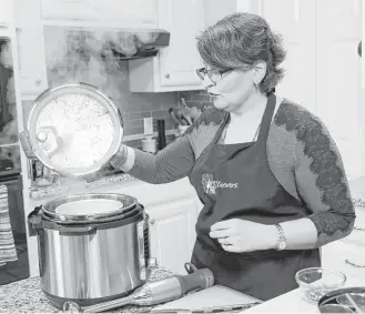  ?? David Woo photos / Dallas Morning News | TNS ?? Urvashi Pitre of Keller prepares butter chicken and checks on her steamed rice in an Instant Pot.