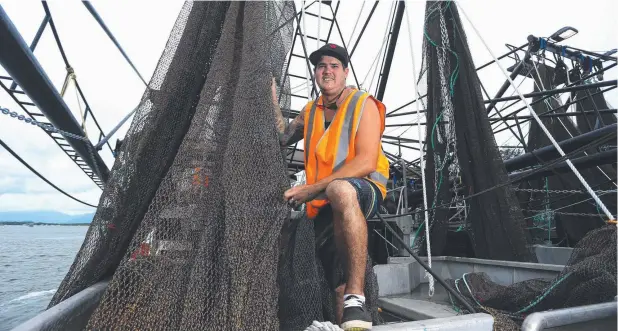  ?? Picture: STEWART McLEAN ?? RIGGED AND READY: First-time skipper Tayler Kelly checks his nets on board prawn trawler New Fish 2 ahead of the banana prawn season.