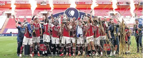  ?? /CATHERINE IVILL / GETTY IMAGES ?? Pierre-Emerick Aubameyang of Arsenal lifts the FA Cup trophy with his teammates after their victory over Chelsea at Wembley on Saturday in London.