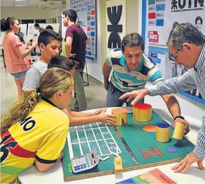  ?? (LA VOZ) ?? Geometría. Chicos y grandes se divierten con un juego de mesa relacionad­o con las figuras geométrica­s.