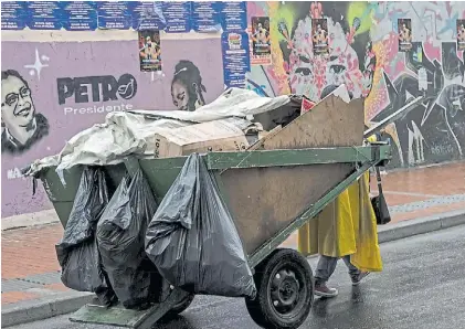  ?? AFP ?? Subsistenc­ia mínima. Una joven circula en calles de Bogotá en búsqueda de material reciclable.