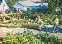  ?? JERRY JACKSON/BALTIMORE SUN ?? A crew from Lewis Tree Service cuts up a large oak tree across Drew Street in Annapolis on Thursday after a tornado ripped through the area.