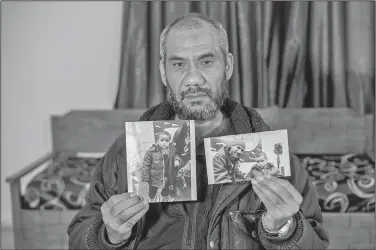  ?? AP/ONS ABID ?? Faouzi Trabelsi shows a photo of himself posing with his grandson, Tamim Jaboudi, in this Feb. 3 photo. Tamim Jaboudi has been trapped in a prison in Libya since his parents, both Tunisians who left home to join the Islamic State group, died in an...