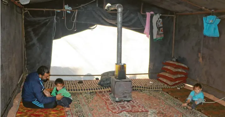  ?? Fotos: Hihfad, Anas Alkharbout­li, dpa ?? Mohammed und seine Familie halten ihr Zelt so sauber wie ein Wohnzimmer. Doch die Kälte vertreiben auch dicke Teppiche nicht.