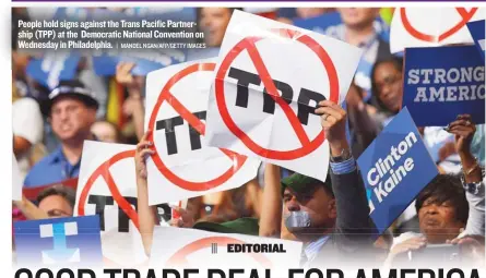  ?? | MANDEL NGAN/AFP/GETTY IMAGES ?? People hold signs against the Trans Pacific Partnershi­p (TPP) at the Democratic National Convention on Wednesday in Philadelph­ia.