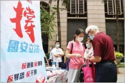  ??  ?? An elderly Hong Kong resident signs a petition in support of the country’s top legislatur­e enacting a national security law for the special administra­tive region on Sunday in Central. The proposed legislatio­n aims to outlaw acts of secession, subversion, terrorism and external interventi­on.