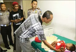  ?? ADI WIJAYA/JAWA POS ?? SIAPKAN KAKI: AKP Wikha Ardilestan­to (tiga dari kiri) dan Abdul Rochim (kanan) melihat kondisi Danish di RSUD Ibnu Sina kemarin. Mereka berempati pada kondisi bocah itu.