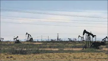  ?? Jeri Clausing Associated Press ?? OIL RIGS churn near Artesia, N.M. In New Mexico, oil and gas account for 42% of state government income, a share that is rising amid the war in Ukraine and record-setting oil production in the Permian Basin.