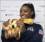  ?? MARIJAN MURAT - THE ASSOCIATED PRESS ?? Simone Biles of the United States shows her five gold medals she won at the Gymnastics World Championsh­ips in Stuttgart, Germany, Sunday, Oct. 13, 2019.