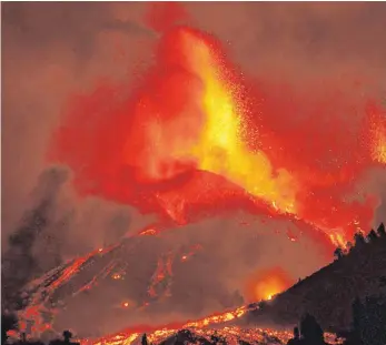  ?? FOTO: EUROPA PRESS/DPA ?? Lava tritt aus einem Vulkan in der Gegend von Cabeza de Vaca auf der kanarische­n Insel La Palma aus. Der Vulkan war am Sonntag erstmals seit 50 Jahren wieder aktiv geworden.