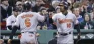  ?? CHARLES KRUPA — THE ASSOCIATED PRESS ?? Baltimore Orioles’ Jonathan Schoop, left, is congratula­ted by Adam Jones after scoring on a double by Caleb Joseph during the fifth inning of a baseball game against the Boston Red Sox at Fenway Park in Boston, Monday.