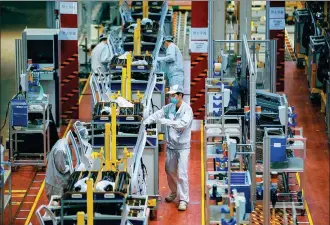  ?? ZHANG DI / FOR CHINA DAILY ?? Employees work on an automobile assembly line in Guangzhou, Guangdong province, on Feb 20.