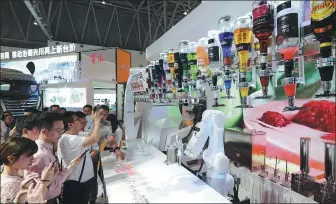  ?? SUN KAIFANG / FOR CHINA DAILY ?? Visitors watch a robot making Moutai cocktails at an internatio­nal investment and trade fair in Southwest China’s Chongqing municipali­ty on May 16.