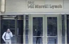  ?? — Reuters ?? A man speaks on his mobile in front of Merrill Lynch building in New York.