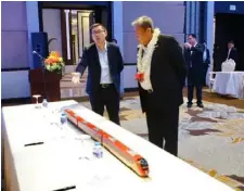  ??  ?? Transporta­tion Secretary Arthur Tugade listens as CRRC Zhuzhou Locomotive General Manager Fu Chengjun explains the features of the standard gauge Diesel Multiple Unit (DMU) during the signing ceremony. (Photo courtesy of DOTr)