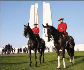  ?? The Associated Press ?? Two RCMP officers sit on their horses prior to a sunset ceremony and mounting of the vigil Saturday at the Canadian National Vimy Memorial in Givenchy-en-Gohelle, France. Commemorat­ion ceremonies will take place today at the memorial.