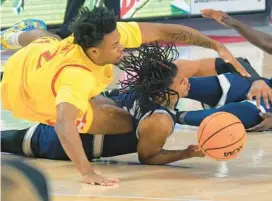  ?? KARL MERTON ?? Maryland guard Jahari Long, left, dives over Saint Peter’s forward Corey Washington for a loose ball during the second half of Thursday night’s game in College Park.