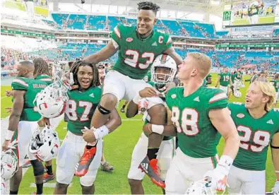  ?? AL DIAZ/TNS ?? Hurricanes teammates carry tight end Christophe­r Herndon IV off the field after Saturday’s win. Coach Mark Richt says he knows navigating success can be a challenge for some players.