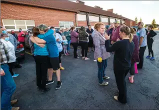  ?? Herald photo by Ian Martens ?? TJ Gilbert, older brother of Myles Gilbert, gets a comforting hug as members of the public gathered at the LDS Stake Centre in Raymond to help search for Myles, who was found safe later in the day. @IMartensHe­rald