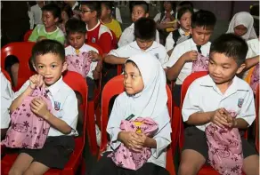  ??  ?? SJK (C) Pui Teh students received goodie bags from the Magnum team, containing sponsored beverages and health supplement­s.