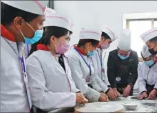  ?? FAN PEISHEN / XINHUA ?? Students learn how to make steamed stuffed buns at a vocational school in a povertystr­icken county in Gansu province last month.