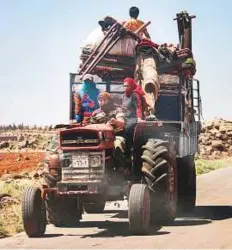  ?? AFP ?? A family rides with belongings on a tractor-drawn trailer as they flee the fighting in the southern Syrian province of Dara’a on Thursday.