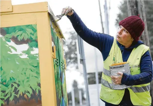  ?? Photos by Elizabeth Conley / Staff photograph­er ?? Houston-based artist Anat Ronen paints a mural to bring attention to human traffickin­g on a Metro cabinet near Moody Park in the Northside.