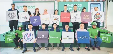  ??  ?? Goh (seated centre) is seen with GrabFood Merchant partners for a group photo.