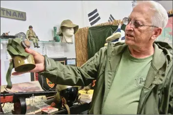  ?? (Special to the Democrat-Gazette/Marcia Schnedler) ?? Volunteer Paul Hicks shows one of the gas masks displayed at the Museum of Veterans and Military History.