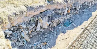  ?? ?? Al excavar para hacer los cimientos de la barda, quedó al descubiert­o la basura