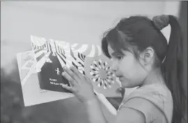  ?? JOSIE LEPE — STAFF PHOTOGRAPH­ER ?? Joy Gutierrez, 5, who is legally blind, reads a book by touch. The Gutierrez family were nominated in 2017 to be recipients of assistance from My New Red Shoes, a Bay Areabased nonprofit that is part of The Mercury News Wish Book program.