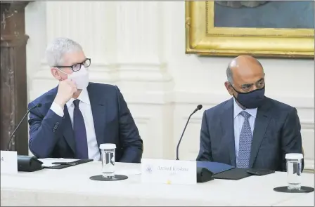  ?? EVAN VUCCI — THE ASSOCIATED PRESS ?? Apple CEO Tim Cook, left, and IBM CEO Arvind Krishna listen as President Joe Biden speaks during a meeting about cybersecur­ity in the East Room of the White House, Wednesday, Aug. 25, in Washington.