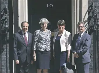  ?? Dominic Lipinski/Associated Press ?? Britain's Prime Minister Theresa May, second from left, with Democratic Unionist Party leader Arlene Foster, DUP deputy leader Nigel Dodds, left, and Member of Parliament Jeffrey Donaldson outside 10 Downing St. in London on Monday.