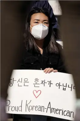  ?? NAM Y. HUH — THE ASSOCIATED PRESS ?? Sophia Sim holds a sign as she attends a rally to support Stop Asian Hate at the Logan Square Monument in Chicago. Stereotype­s about Asian American women are evident throughout U.S. popular culture in the form of novels and movies.