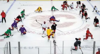  ?? ?? Flames players stretch during team practice in Calgary on Tuesday. The Battle of Alberta, with Calgary rival the Edmonton Oilers, began Wednesday night.