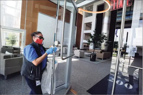  ?? Hearst Connecticu­t Media file photo ?? Maria Lima, a custodial porter at the Building and Land Technology-owned office building at 200 Elm St. in downtown Stamford wipes down surfaces on May 15 in the front lobby.