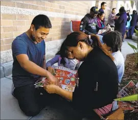  ?? Gary Coronado Los Angeles Times ?? HECTOR BEJAR, 14, and his mother, Marina Jimenez, of Hawthorne spend part of their Thanksgivi­ng this year waiting in line at Target in Carson for deals.
