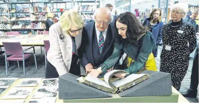  ??  ?? Record books: President Michael D Higgins and his wife Sabina (left) look at a book with historian Catherine Morris on a visit to Liverpool Central Library