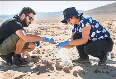  ?? MARTIN BERNETTI / AGENCE FRANCE-PRESSE ?? Biologists Cristiana Dorador (right) and Jonathan Garcia search for rock samples to analyze them in Yungay in the Atacama desert, 80 kilometers south of Antofagast­a, Chile. The Atacama is one of the most arid areas in the world and scientists believe...
