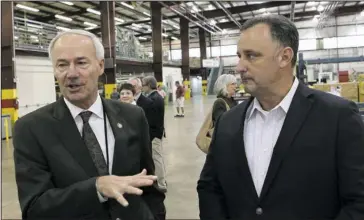  ?? The Sentinel-Record/Richard Rasmussen ?? GOVERNOR VISIT: Arkansas Gov. Asa Hutchinson, left, and Joe Greenwood, vice president of business developmen­t at Triumph Product Support, talk to The Sentinel-Record during the governor’s tour of the business on Wednesday.