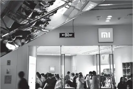  ??  ?? People visit a Xiaomi store in Beijing in this file photo. The Chinese smarphone maker will raise US$6.1 billion as it launched its initial public offering yesterday, below the expected US$10 billion. — Reuters