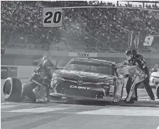  ?? AP PHOTO/RICK SCUTERI ?? The pit crew for NASCAR driver Christophe­r Bell services his car during Saturday’s Xfinity Series at ISM Raceway in Avondale, Ariz. Bell delivered in a must-win situation and will race for the title next weekend.