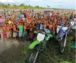  ??  ?? Swamped ... locals greet riders at Busu River, Lae (above); tough going on the Bumbu River (right).