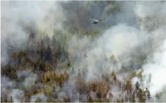  ?? ?? A helicopter f lies over a fire in BC last year. Photo via Shuttersto­ck.