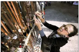  ?? Arkansas Democrat-Gazette/THOMAS METTHE ?? Kathleen Kennally looks at necklaces on display at last year’s Bizarre Bazaar. This year’s local craft market in the River Market Pavilions is set for Saturday.