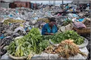  ?? (File Photo/AP/Rodrigo Abd) ?? A woman selling greens waits for customers Sept. 22 in the Croix des Bosalles market in Port-au-Prince, Haiti. The floor of the market is thick with decomposin­g trash.